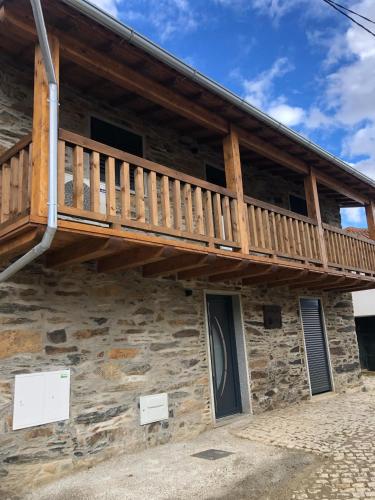 a log cabin with a deck on the side of it at Casa da Lúcia in Bragança