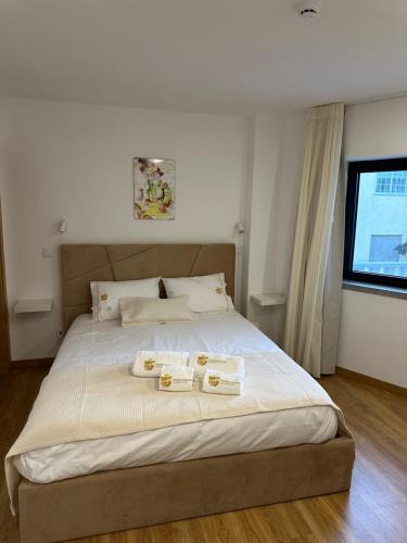 a bedroom with a large bed with two towels on it at Figuras Mágicas in Trancoso