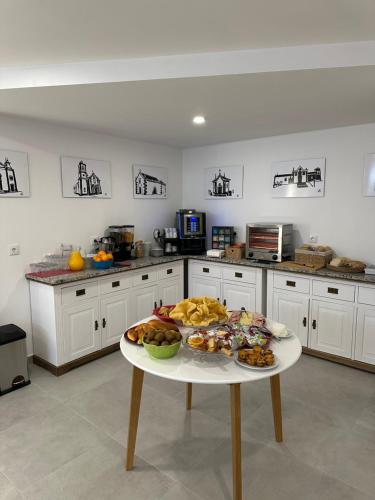 a white kitchen with a table with food on it at Figuras Mágicas in Trancoso