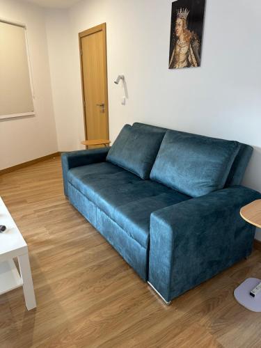 a living room with a blue couch in a room at Figuras Mágicas in Trancoso
