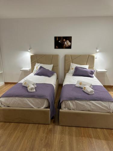 two beds sitting next to each other in a bedroom at Figuras Mágicas in Trancoso