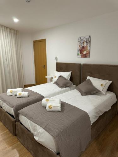 two beds sitting next to each other in a bedroom at Figuras Mágicas in Trancoso