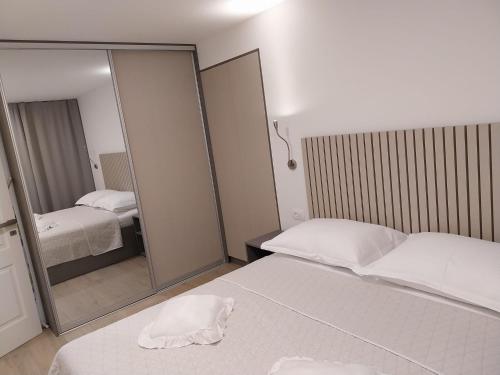 a bedroom with two beds and a large mirror at Divna in Imotski