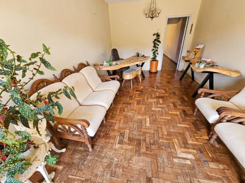 a living room with couches and tables and plants at Atalho Guest House in Cunha