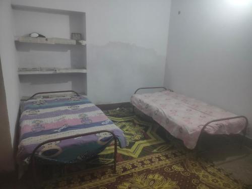 2 camas sentadas en una habitación con alfombra en Srivastava House, en Prayagraj