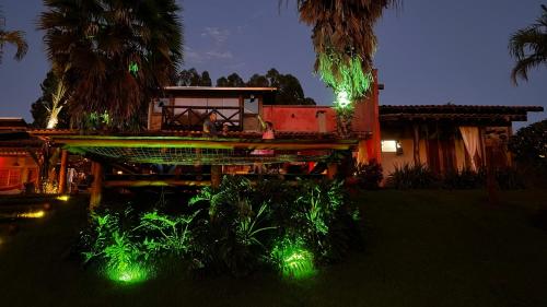 a house with green lights in the yard at night at Rancho Recanto da Serra in Delfinópolis