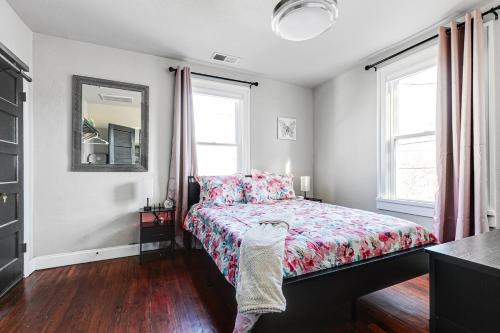 a bedroom with a bed and two windows at Tranquil Escape in Church Hill Near Libby Park in Richmond
