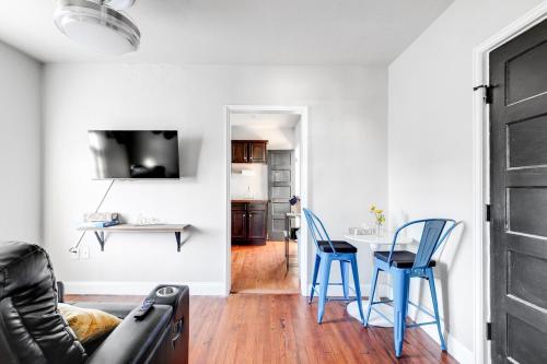 a living room with a table and blue chairs at Tranquil Escape in Church Hill Near Libby Park in Richmond