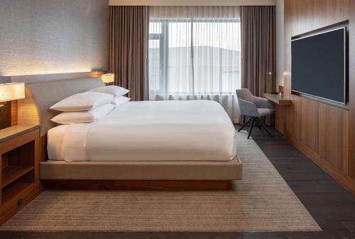 a hotel room with a bed and a flat screen tv at Hyatt Regency Lake Washington at Seattle's Southport in Renton