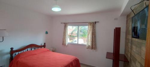 a bedroom with a red bed and a window at Los Nardos Duplex 3 in San Salvador de Jujuy