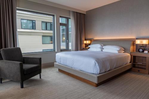 a bedroom with a bed and a chair and a window at Hyatt Regency Lake Washington at Seattle's Southport in Renton