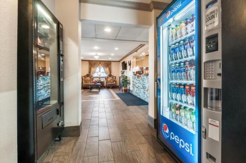 a pharmacy aisle with a drink cooler in a store at American Inn & Suites Metro Airport in Romulus