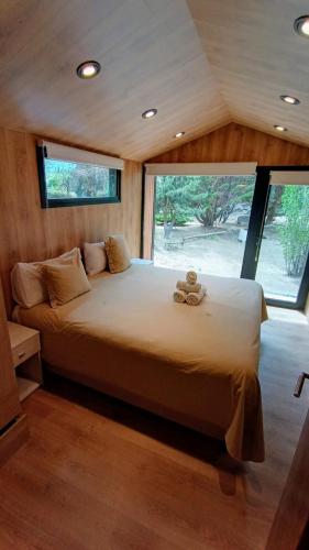 a large bed in a room with a large window at Hosteria Hainen in El Calafate