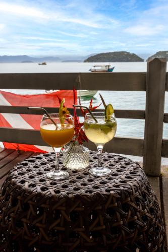 two wine glasses sitting on top of a table at Pousada Cruzoé in Praia de Araçatiba