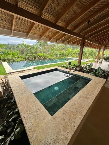 a swimming pool in the middle of a house at Chachagua Rainforest Hotel & Hot Springs in Fortuna