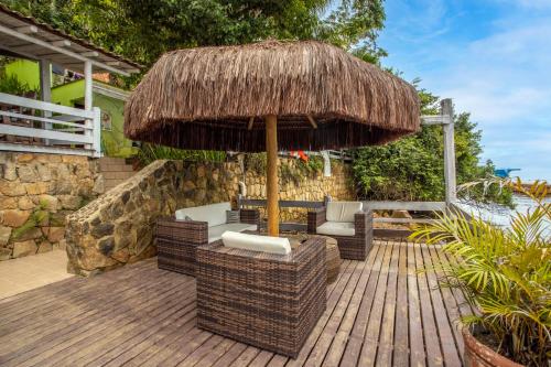 an umbrella and chairs on a wooden deck at Pousada Cruzoé in Praia de Araçatiba