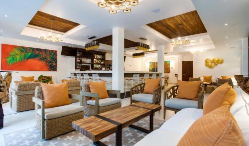 a restaurant with tables and chairs and a bar at Belizean Dreams Resort in Hopkins