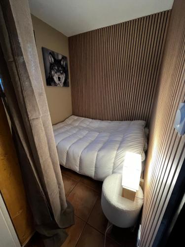 une petite chambre avec un lit et une chaise dans l'établissement Appartement Cosy avec jardin, aux Angles