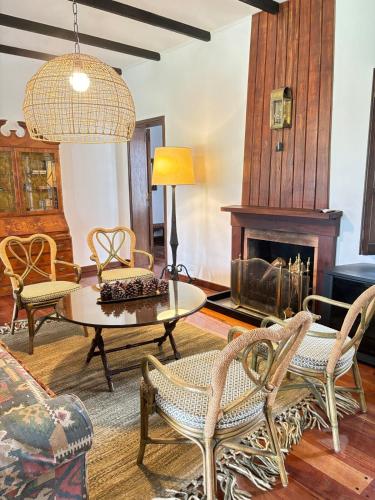 a living room with a table and chairs and a fireplace at La Danesa - Casa de campo en la naturaleza a 25 min del centro in Tandil