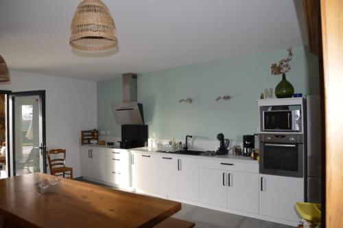 a kitchen with white cabinets and a stove top oven at Des Racines et des Rêves in Vidou