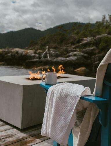 a table with a fireplace with a towel on it at Lux Remote Glamping Hideaway in Ucluelet
