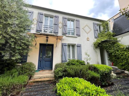 a white house with blue doors and windows at Maison cosy et moderne aux portes de Paris in Saint-Maur-des-Fossés
