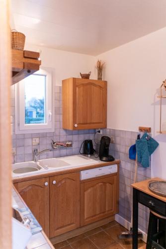 une cuisine avec des armoires en bois et un évier dans l'établissement Maison sur la plage , pour vivre des vacances iodées 