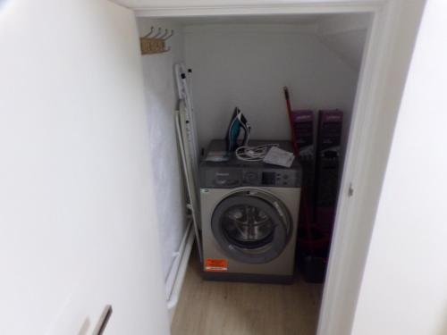 a washer and dryer in a small room at 3TheDome - Luxury Ground Floor Apartment opposite the Beach, Barton on Sea in Barton on Sea