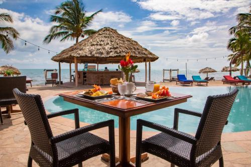 a table with a meal on the beach at a resort at Belizean Dreams Resort in Hopkins