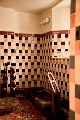 a bathroom with a toilet and checkered wall at Grand Hotel Bellevue London in London
