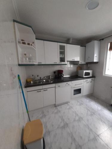 a kitchen with white cabinets and a sink at Dreams Work - Your refuge in Burgos in Burgos