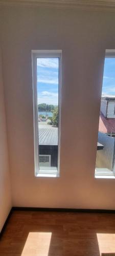 an empty room with two windows and a view at cabaña centrica con vista al rio in Valdivia