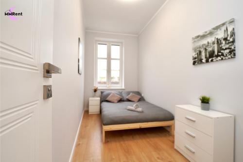 a small bedroom with a bed and a window at MMRent Manhattan Room in Gdańsk