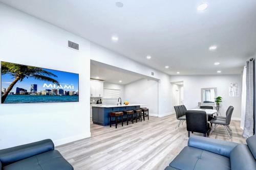 a living room with a blue couch and a kitchen at Walk to Beach Luxury 4BR & 4BA Villa Hollywood Lakes in Hollywood