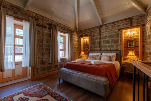 a bedroom with a bed and a brick wall at Orion Adatepe in Adatepe
