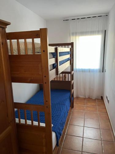 a bedroom with two bunk beds and a window at Miel y Flor - Casa en Les Oliveres ideal para familias in Perelló