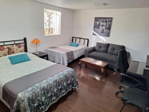 a hotel room with two beds and a couch at Casa Miranda Airport in Mexico City