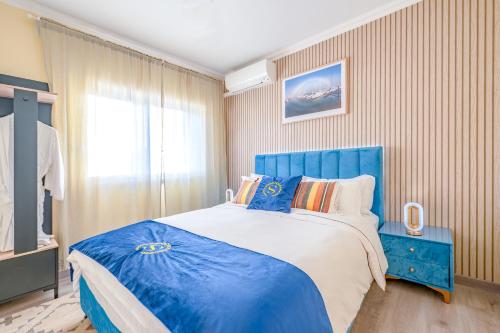 a bedroom with a blue bed and a window at Gold Coast Photography Inn in Estoril