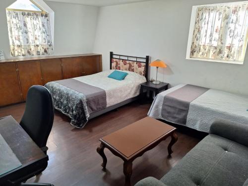 a hotel room with two beds and a couch at Casa Miranda Airport in Mexico City
