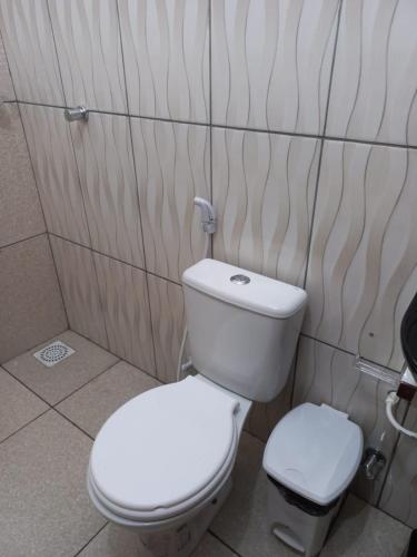 a bathroom with a white toilet in a room at Pousada Manu Guajiru in Trairi