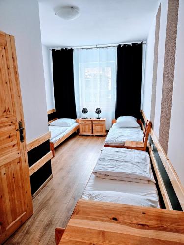 a bedroom with two beds and a window at Wellness Hostel Polskie Wrota in Lewin Kłodzki