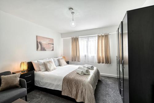 a bedroom with a bed and a chair and a window at Central Nottingham 3 bed house with Driveway in Nottingham