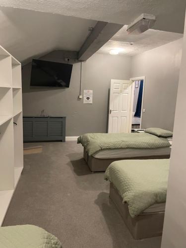 a bedroom with two beds and a tv on the wall at Top of the Town in Eas Géitine