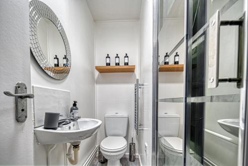 a bathroom with a sink and a toilet and a mirror at Central Nottingham 3 bed house with Driveway in Nottingham