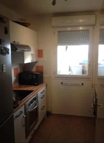 Il comprend une petite cuisine avec une fenêtre et une cuisinière. dans l'établissement Apartment with Terrace La Défense, à Courbevoie