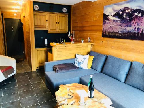 un salon avec un canapé bleu et une table dans l'établissement Superbe duplex with Hammam-Spa in Megève, à Megève