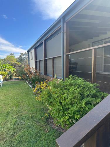 a house with a bench in front of a yard at 1 Tree Escape in Wooli