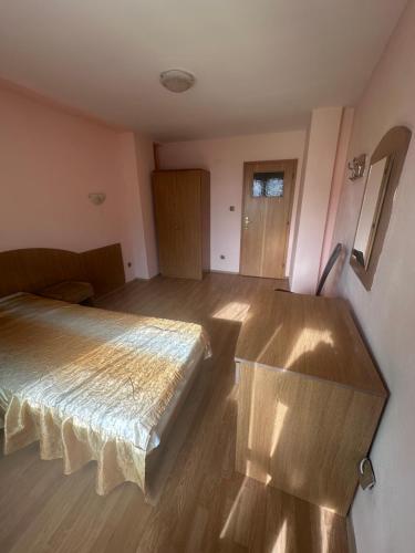 a bedroom with a bed in a room with wooden floors at Hotel MERIDA in Blagoevgrad