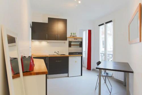 une cuisine avec un comptoir et une table à l'intérieur dans l'établissement Lovely apartment 10 min walk to Louvre 3 Persons, à Paris