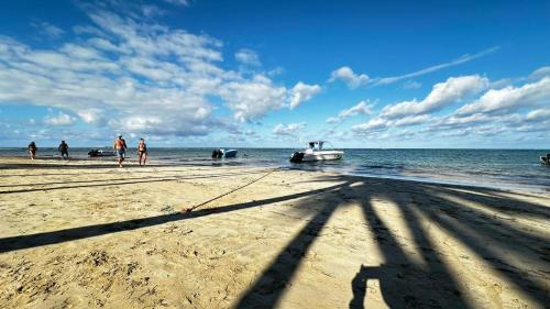 a group of people on a beach with a boat in the water at Casa Ballenas1 SF in Las Terrenas
